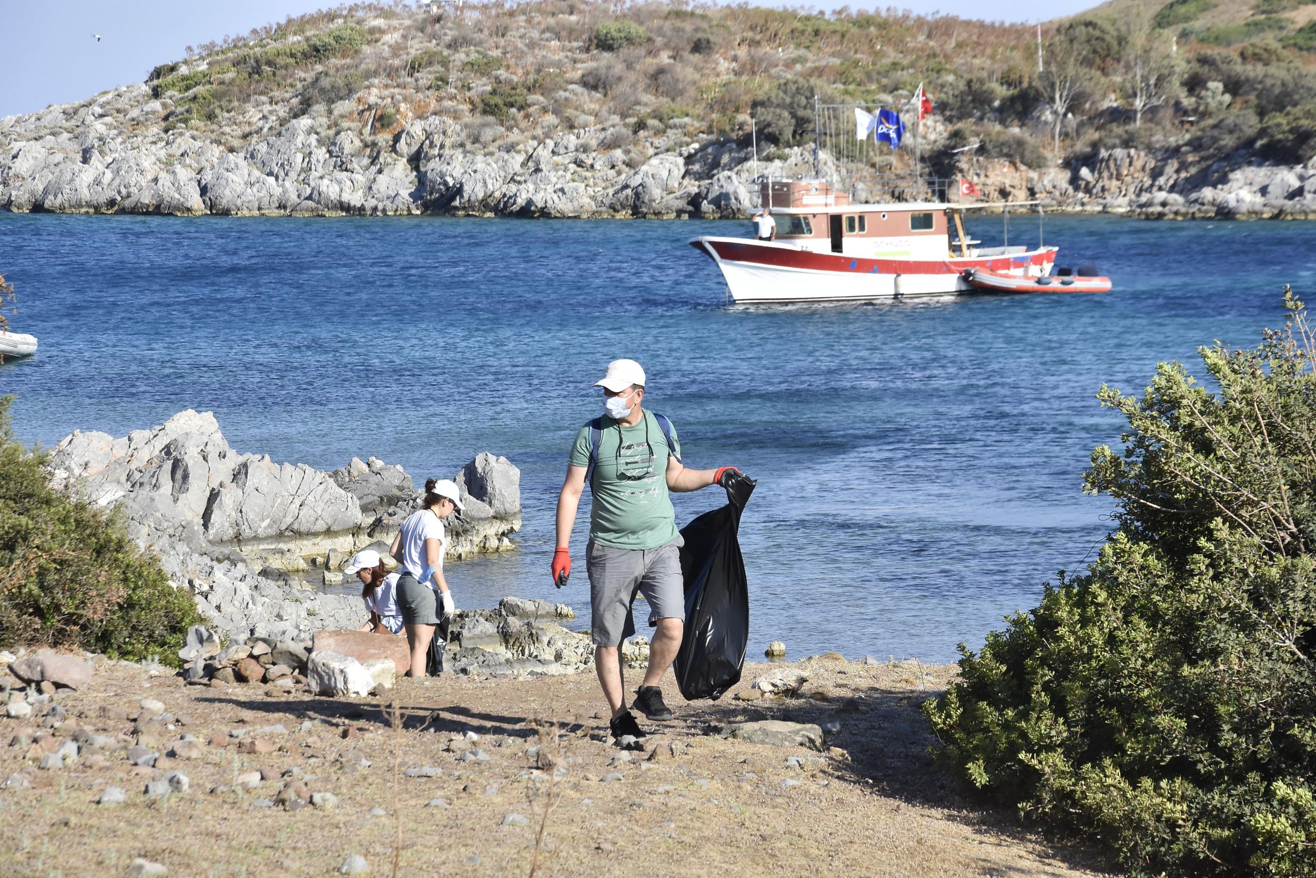 Muğla'da teknelerle ulaşılan plajda çevre ve deniz dibi temizliği yapıldı
